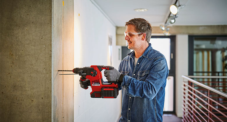 Man drilling in a wall with a rotary hammer