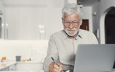 A man writing something down on a piece of paper. 